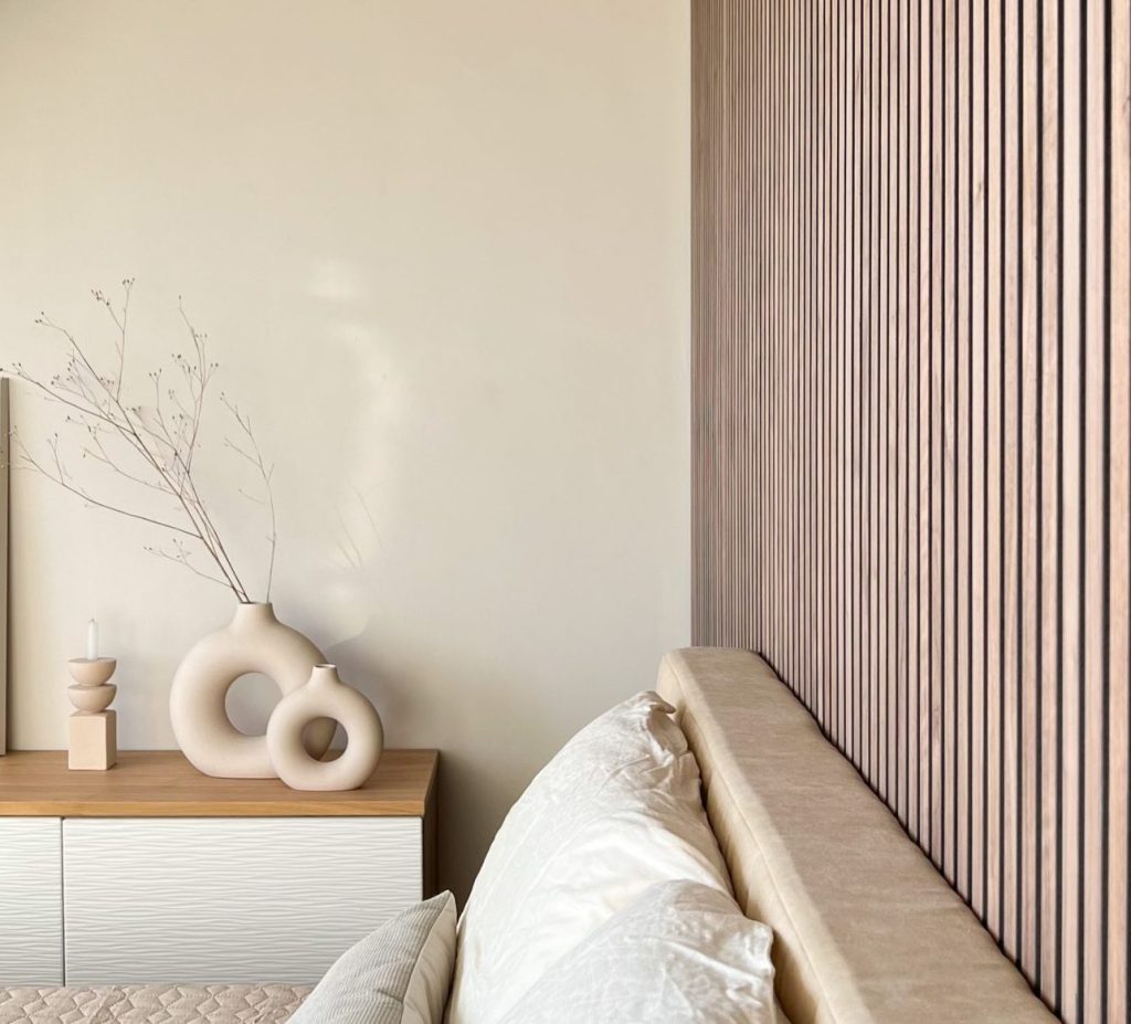 Walnut akupanel with a floor to ceiling headboard, seen from the side